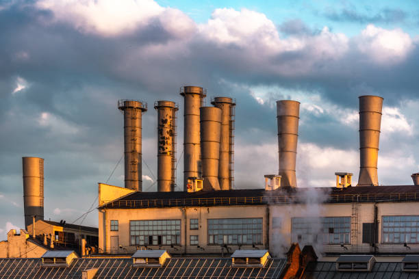 Industrial building with steaming pipes at sunset. Dramatic clouds on background. Moscow