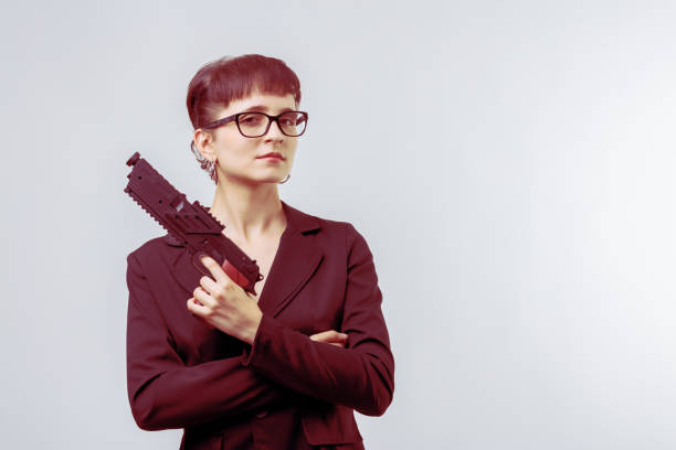 Businesswoman is holding a gun and standing with her arms crossed, representing concepts of power, confidence, and defense in the corporate world