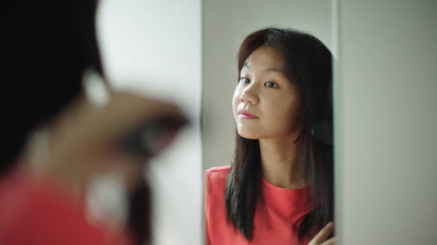 istock Young girl using hair straighteners. 2160856867