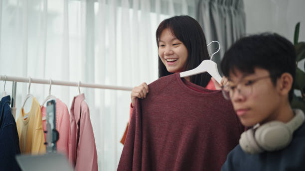 istock Teenagers live-streamed ecommerce sell clothes. 2160856907