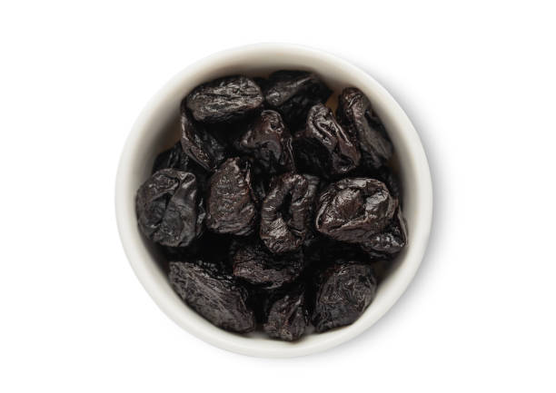 istock Ceramic bowl with sweet dried plums prunes isolated on white background.Top view. 2160864458