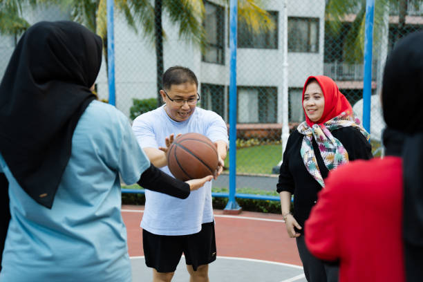 istock Coach giving practice example to basketball team during practice in gym 2160878113
