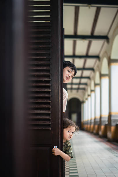 two boys peeking through doorway
