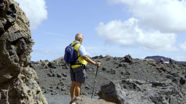 istock Active senior man over 70 years old hiking on the volcano 2160880846