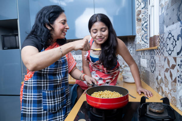 istock indian mother daughter cooking together in kitchen 2160884525