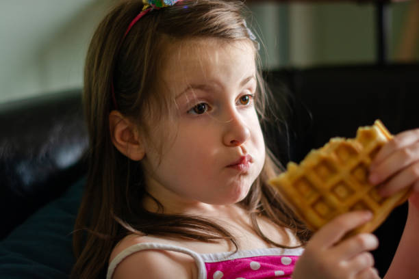 istock Girl is eating waffles at home 2160886682