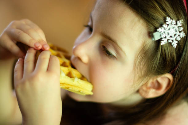 istock Girl is eating waffles at home 2160886822