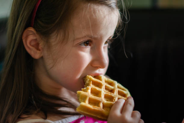 istock Girl is eating waffles at home 2160887466