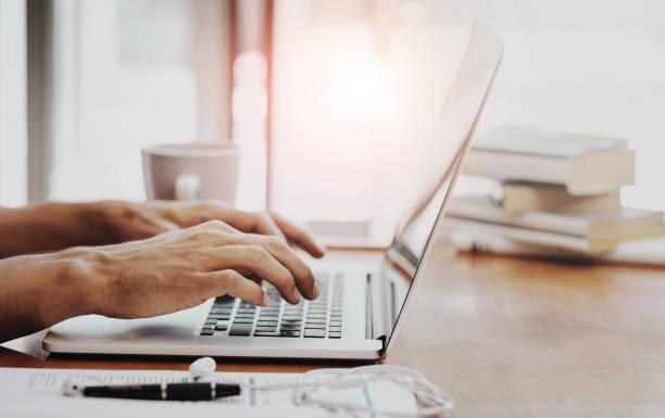Hands, laptop and typing for remote work from home office with notebook, review and editing for article. Person, writer and computer with click, keyboard and digital newsletter for creative agency