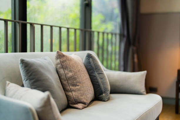 Comfortable living room featuring a blue couch adorned with yellow cushions and surrounded by plants