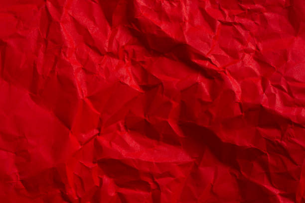 Wrinkled red paper texture,Rectangular crumpled sheet of red paper on a white isolated background