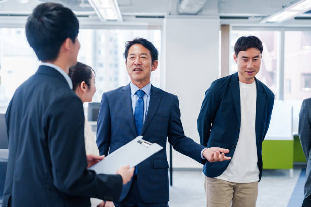 istock Business people standing around in an office 2160903084