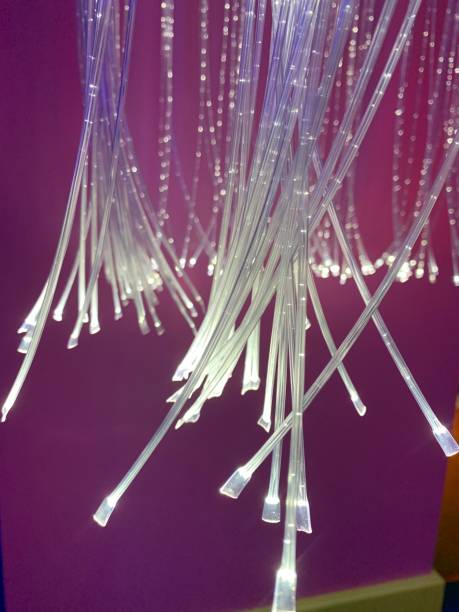 White Fibre optic cables with a purple background, perspective focus