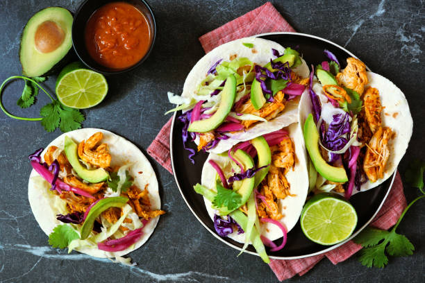 Chicken street tacos, top down view table scene on a dark stone background