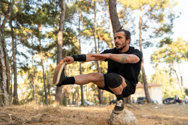 An open-air professional athlete performing calisthenic movements in the forest