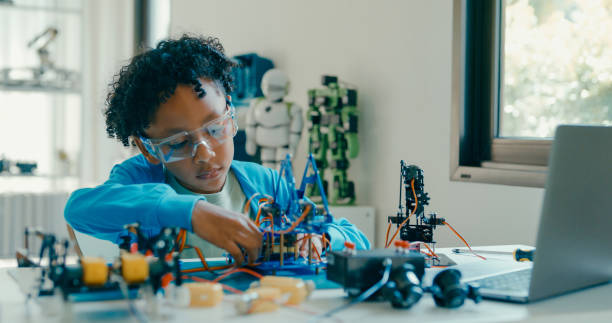 istock Young African-American boy in STEM education by assembling robot at home. STEM Education robotics courses online. 2160910154
