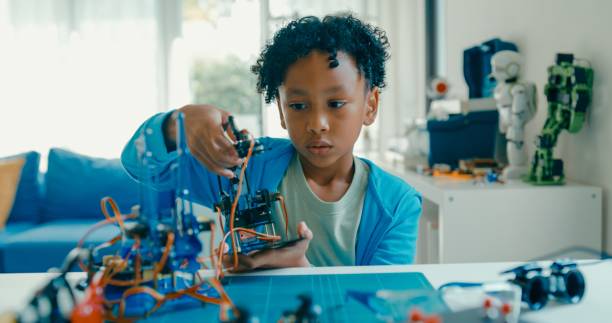 istock Young African-American boy in STEM education by assembling robot at home. STEM Education robotics courses online. 2160910185
