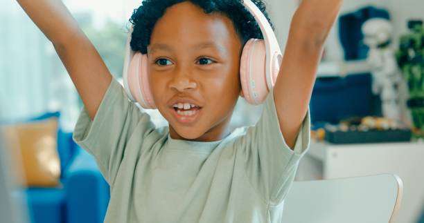 istock Closeup of Enthusiastic young African-American boy interacts with online class using laptop and digital tablet, fully absorbed in educational activities at home. Education courses online. 2160910232