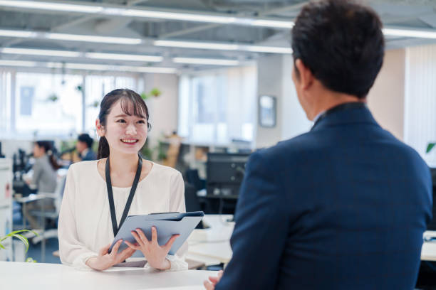 istock Female staff handling visitors at the counter. 2160910395