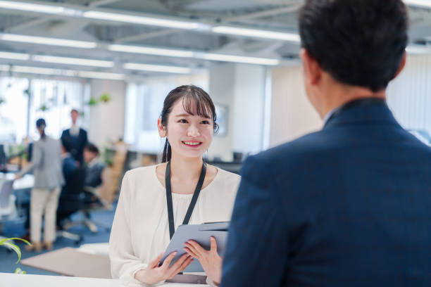 istock Female staff handling visitors at the counter. 2160910397