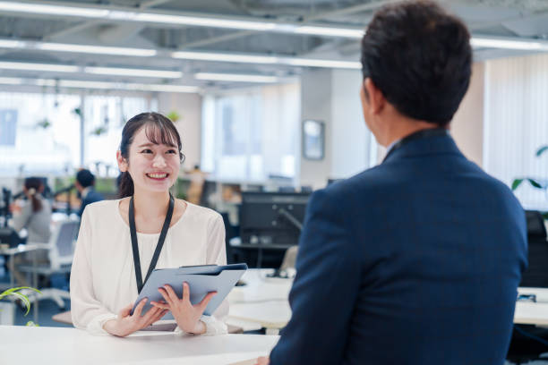 istock Female staff handling visitors at the counter. 2160910401