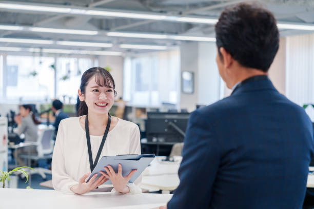 istock Female staff handling visitors at the counter. 2160910402