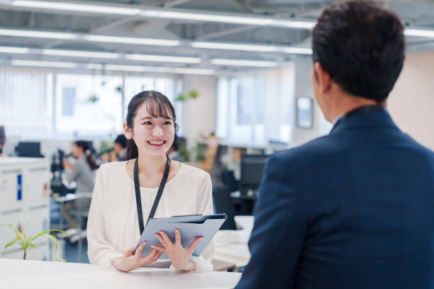 istock Female staff handling visitors at the counter. 2160910409
