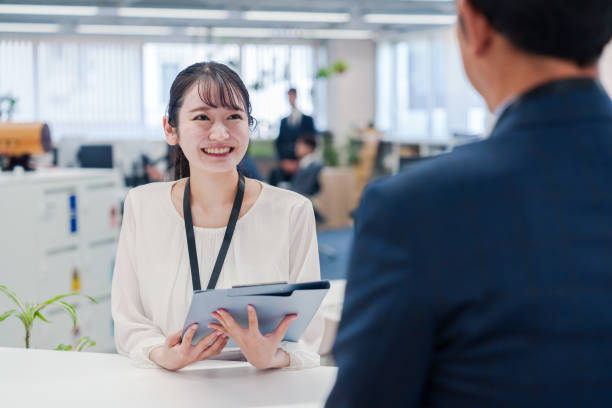 istock Female staff handling visitors at the counter. 2160910411