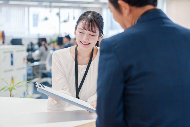 istock Female staff handling visitors at the counter. 2160910417