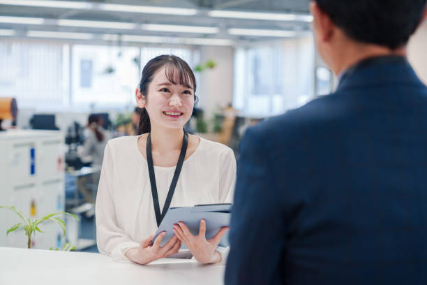 istock Female staff handling visitors at the counter. 2160910419