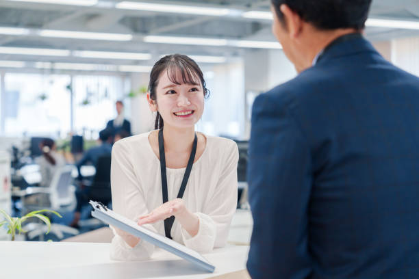 istock Female staff handling visitors at the counter. 2160910423