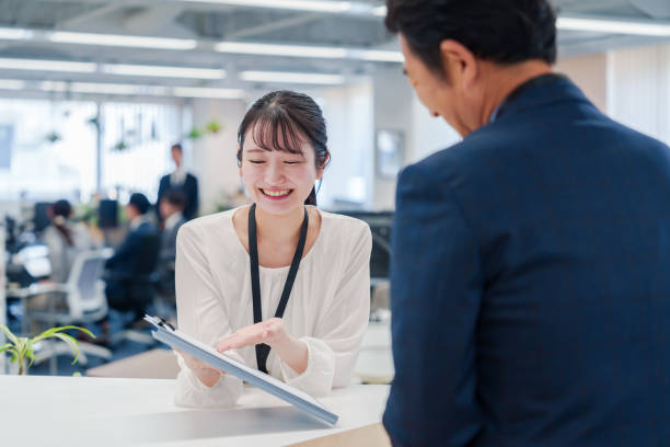 istock Female staff handling visitors at the counter. 2160910424