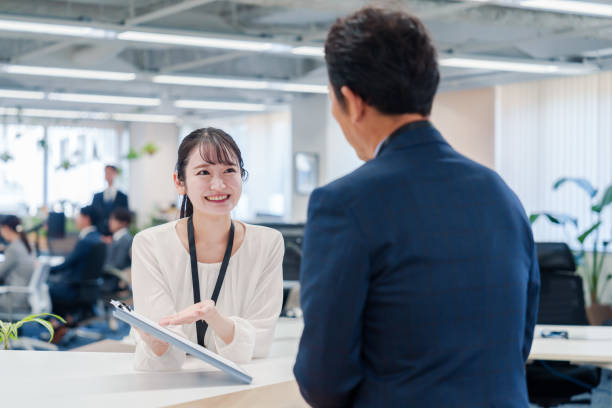 istock Female staff handling visitors at the counter. 2160910426