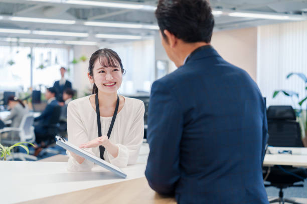 istock Female staff handling visitors at the counter. 2160910428