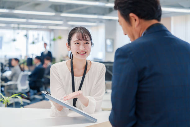 istock Female staff handling visitors at the counter. 2160910430