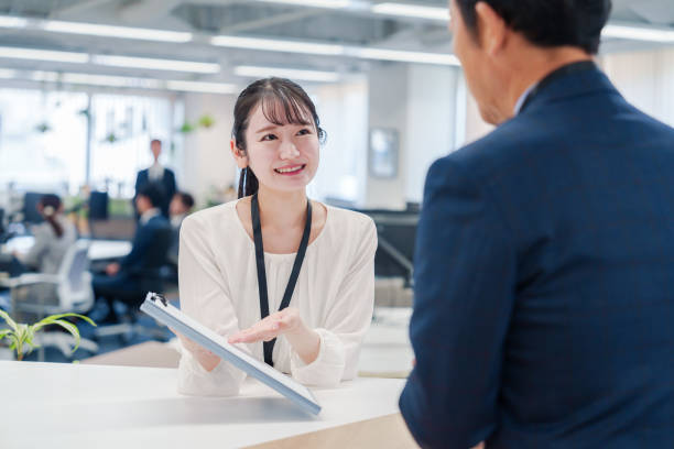istock Female staff handling visitors at the counter. 2160910441