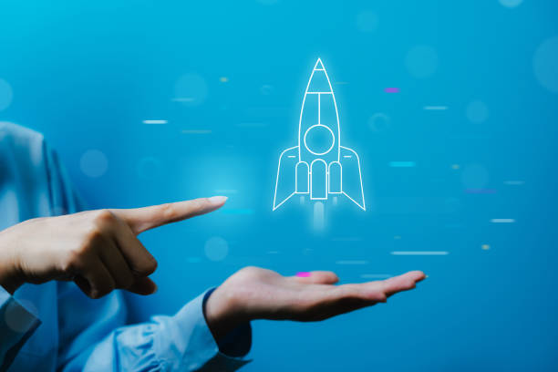 istock Hand pointing at a rocket hologram, symbolizing innovation, technology, and futuristic concepts on a blue background. 2160912815