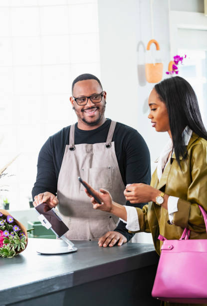 istock Customer in gift shop using mobile phone to pay 2160915054