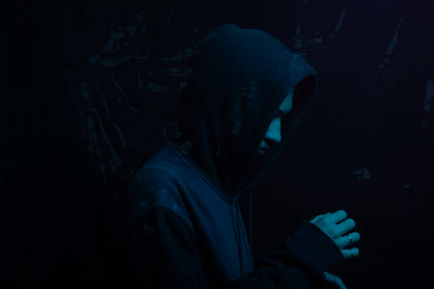 istock Young man wearing gray sweatshirt hiding his face. Studio portrait. 2160924997