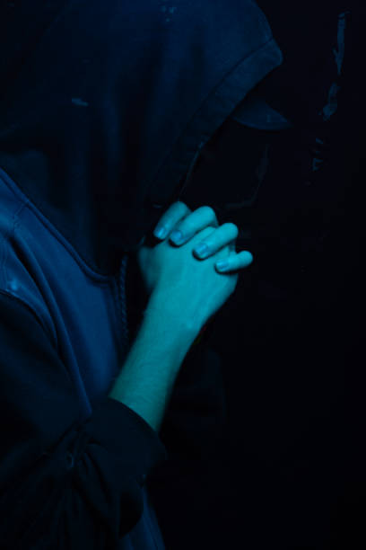 istock Young man wearing gray sweatshirt hiding his face. Studio portrait. 2160925003