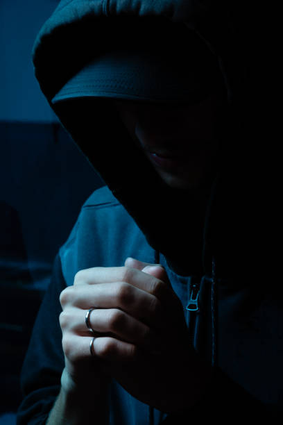 istock Mysterious young man in gray coat hiding his face. Studio portrait. 2160925006