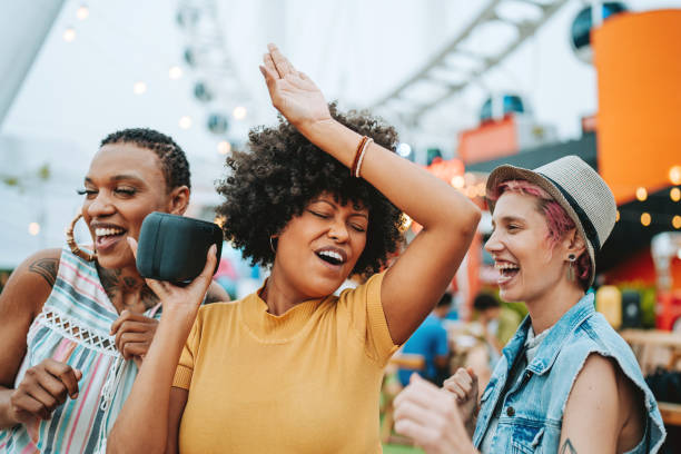 istock Three friends having fun listening to music on the bluetooth speaker 2160927090