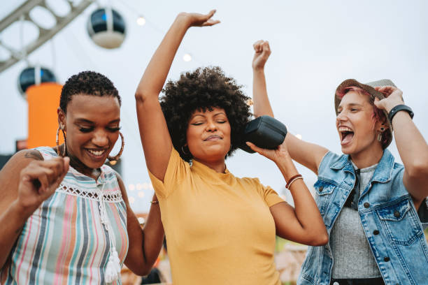 istock Three friends having fun listening to music on the bluetooth speaker 2160927125