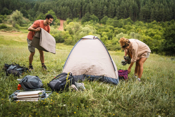 istock Couple pack a tent after finish camp trip 2160930112
