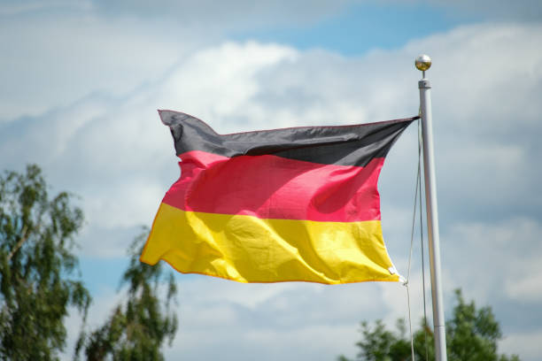 istock German Flag Waving On A Flagpole Against Blue Sky With Clouds, Wallpaper 2160930252