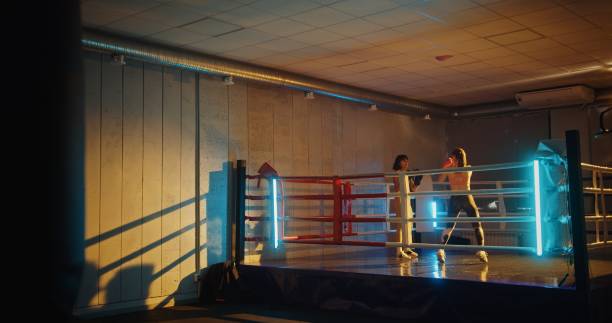 istock Two young women entering boxing ring for training sparring session in a modern gym with colorful lighting showcasing intense preparation and fitness dedication 2160936829