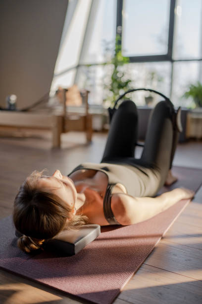 istock A woman is using a hip Magic Circle at Glute bridge Pilates workout in studio, being active and committed to exercising 2160937950
