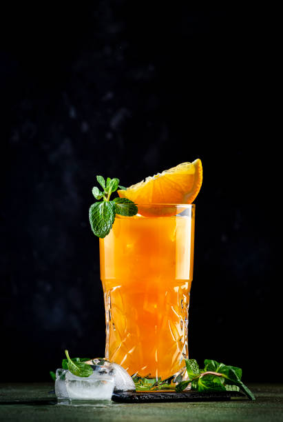istock Summer alcoholic cocktail drink with vodka, rum, orange juice,  crushed ice and mint. Black background 2160940620