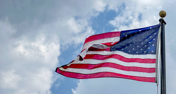 istock American Flag flying on a windy, cloudy day 2160941612