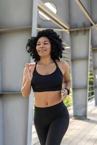 istock Brunette woman in black top running and looking concentrated 2160945314